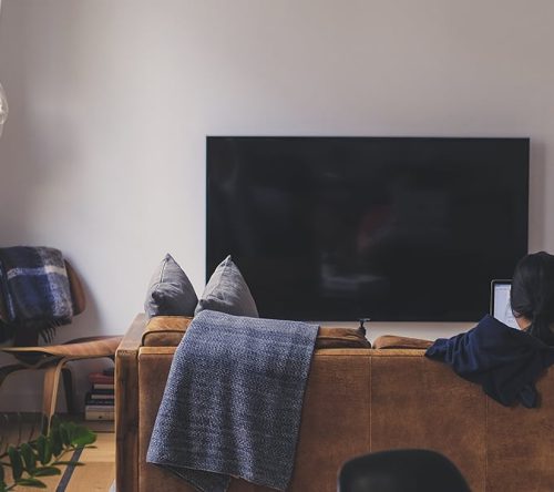 Braunes Sofa von hinten mit Fernseher