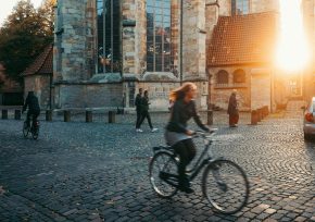 Frau mit Rad vor Kirche